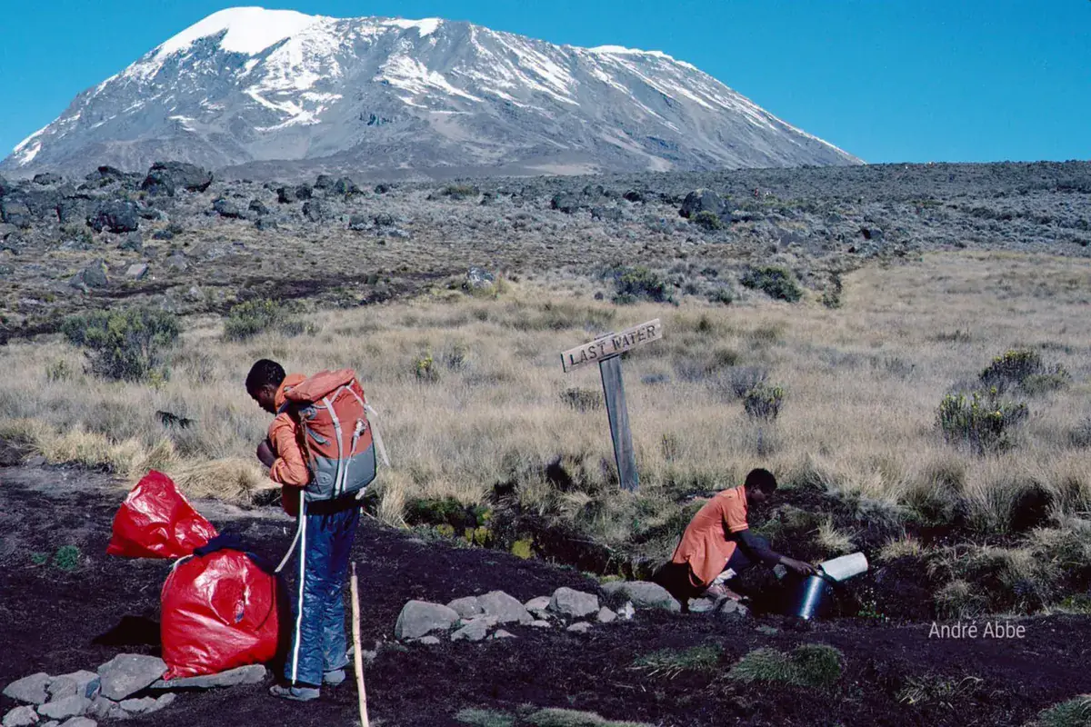 Deux ramasseurs nettoient un sentier au pied du Kilimandjaro